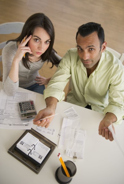 Couple doing taxes and looking at camera.