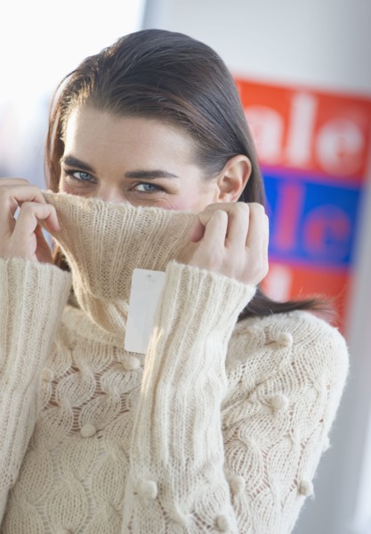 Young woman pulling collar over mouth.