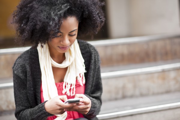 USA, Washington State, Seattle, Cheerful young woman text messaging. Photo : Take A Pix Media