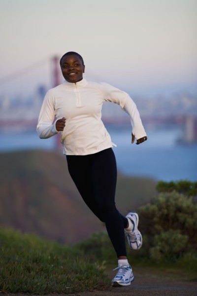 USA, California, San Francisco, Woman jogging, Golden Gate Bridge in background. Photo : Noah