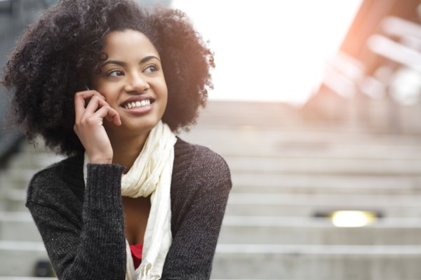 USA, Washington State, Seattle, young woman sitting on steps and talking on mobile phone. Photo :