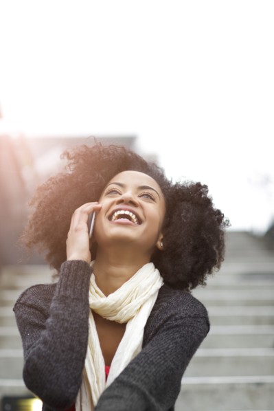 USA, Washington State, Seattle, young woman sitting on steps and talking on mobile phone. Photo :
