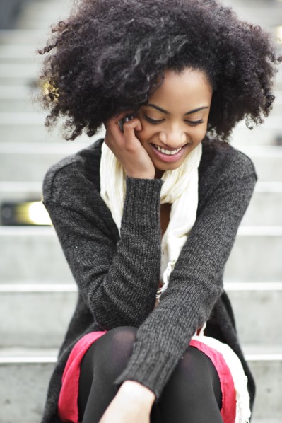 USA, Washington State, Seattle, young woman sitting on steps and talking on mobile phone. Photo :
