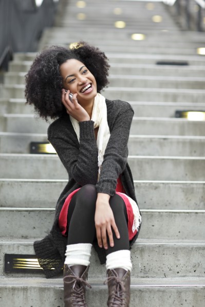 USA, Washington State, Seattle, young woman sitting on steps and talking on mobile phone. Photo :