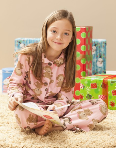 Portrait of girl (6-7) preparing Christmas presents. Photo : Mike Kemp