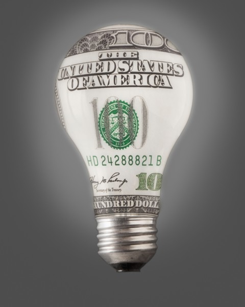 Composition of bulb and one hundred dollar note. Photo : Mike Kemp