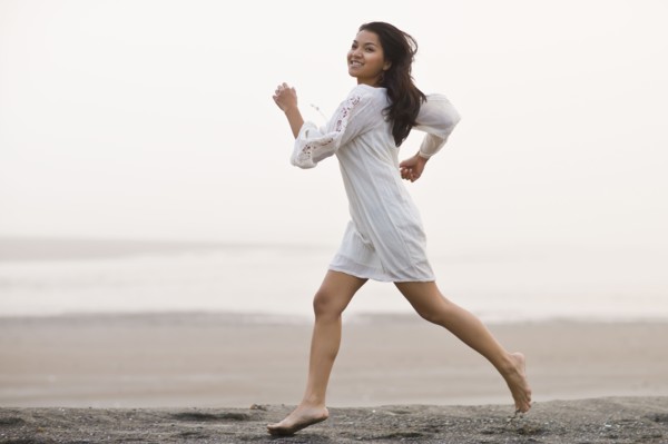 USA, Montana, young woman jogging on beach. Photo : Noah Clayton
