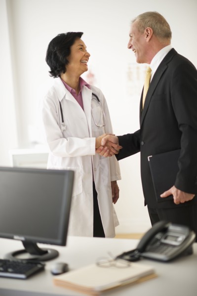 Female doctor shaking hands with hospital executive.