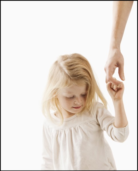 Studio shot of girl (2-3) holding adult's hand. Photo : Mike Kemp
