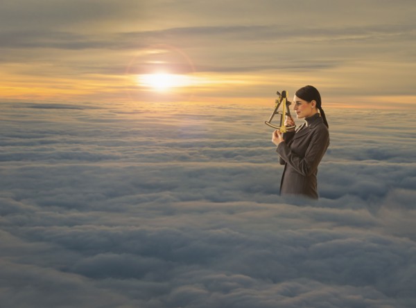 Women above clouds looking through sextant.