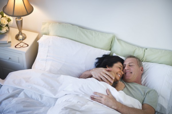 Happy mature couple laying in bed.