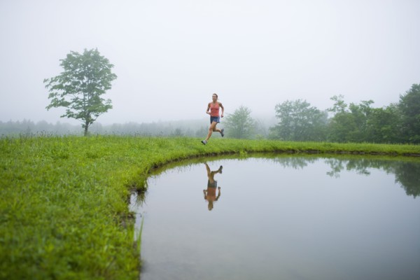 USA, Vermont, Landgrove, Woman jogging by lake. Photo : Noah Clayton