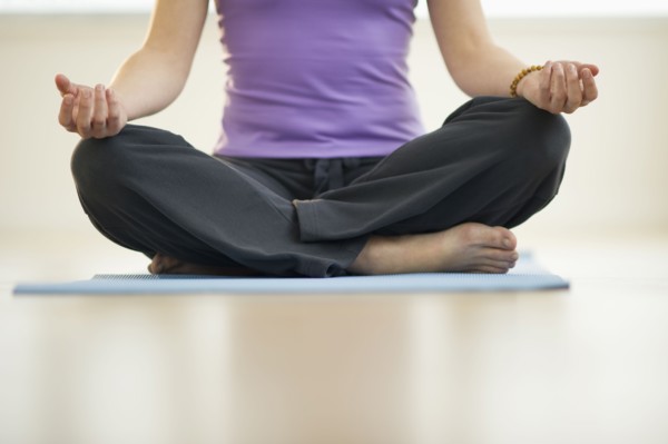 Young woman meditation in lotus position, low section.