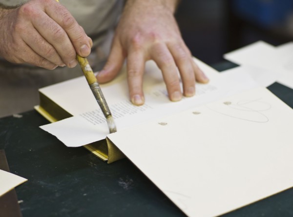 Craftsman making book bindings.