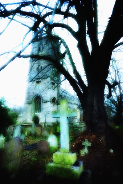 United Kingdom, Bristol, Trees and gravestones outside church.