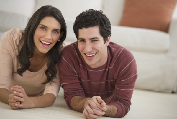Portrait of couple lying on floor.