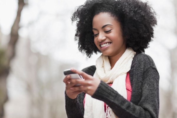USA, Washington State, Seattle, Cheerful young woman text messaging. Photo : Take A Pix Media