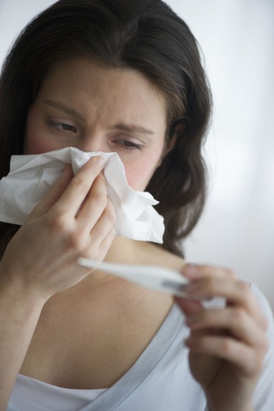 Woman with flu blowing nose.
