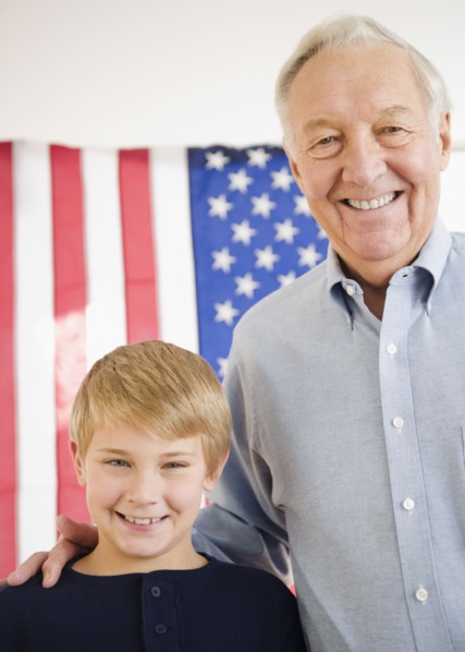 Portrait of grandfather with grandson (8-9) with American flag. Photo : Jamie Grill Photography