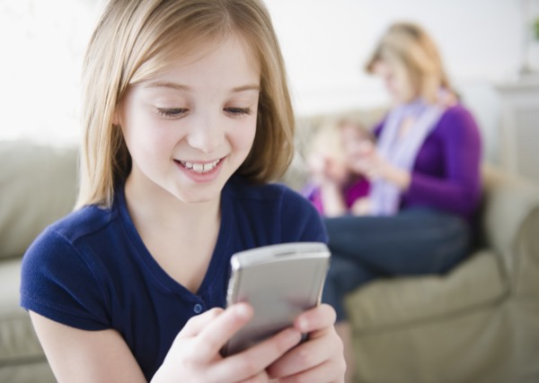 Girl (10-11) holding remote control. Photo : Jamie Grill Photography