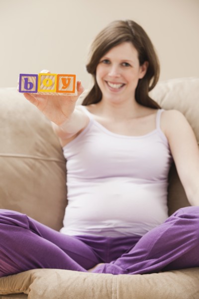 Young pregnant woman holding plastic letters reading: 'boy'. Photo: Mike Kemp