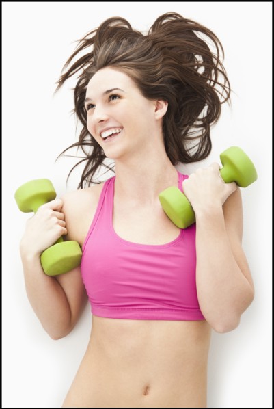 Young woman holding hand weights. Photo : Mike Kemp