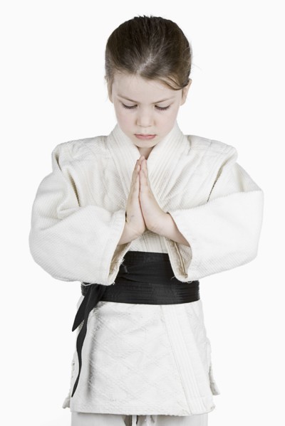 Studio portrait of girl (6-7) wearing karate uniform. Photo: Justin Paget