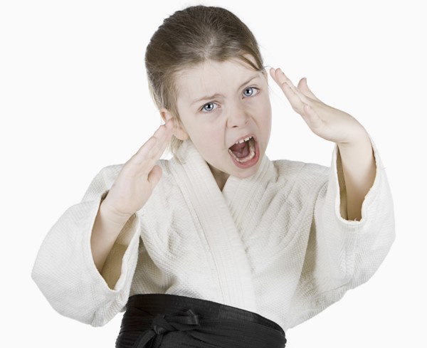 Studio portrait of girl (6-7) wearing karate uniform. Photo: Justin Paget