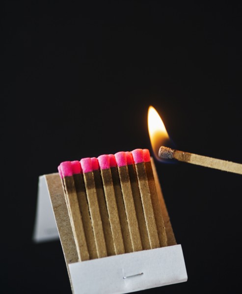 Close up of matches with one burning.