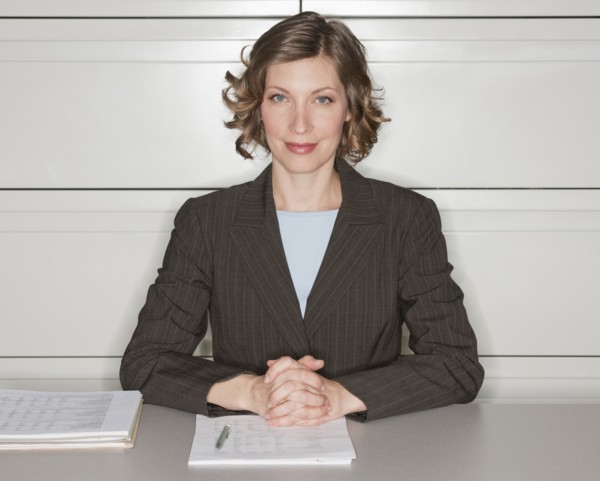 Portrait of woman in office sitting at desk.