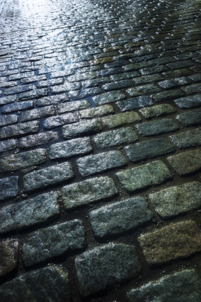 USA, New York, New York City, close up of cobblestone street at night.