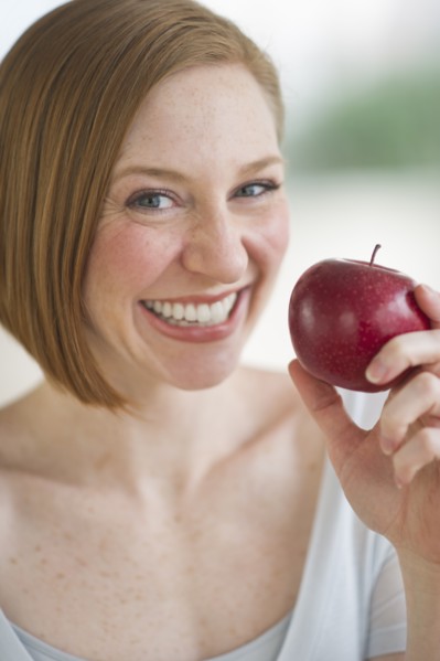 Woman holding fresh apple.