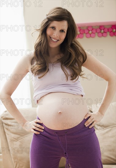Young pregnant woman showing belly. Photo: Mike Kemp