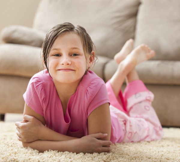 Portrait of girl (10-11) lying on floor. Photo : Mike Kemp