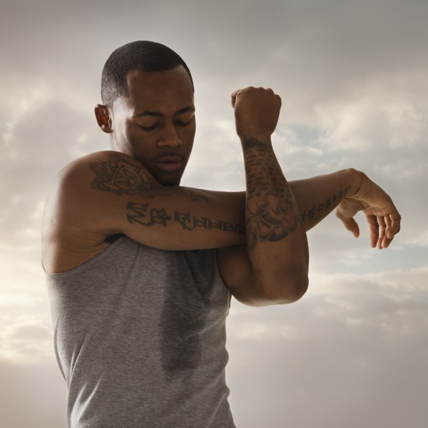 Young man exercising, cloudy sky in background. Photo: Mike Kemp