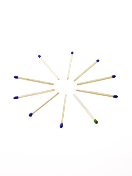 Blue matches with one green on white background. Photo: David Arky