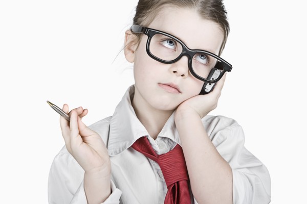 Studio portrait of girl (6-7) dressed-up as businesswoman. Photo : Justin Paget