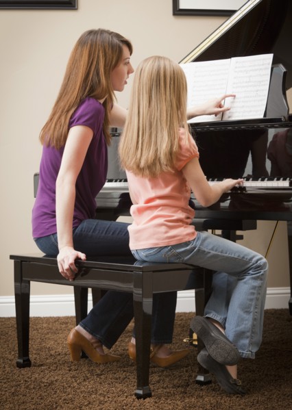 Girl (8-9) and mother playing grand piano. Photo: Mike Kemp