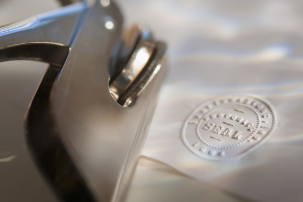 Close up of stamper and corporate seal on paper.