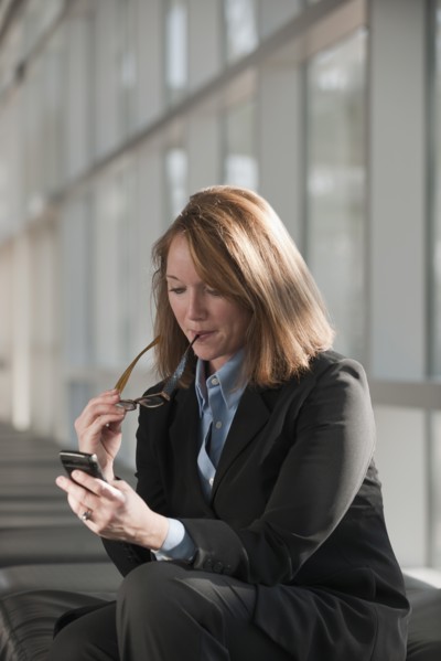 Businesswoman text-messaging. Photo : Mark Edward Atkinson