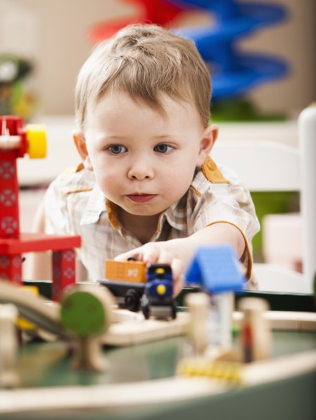 Boy (2-3) playing with toy train. Photo: Mike Kemp
