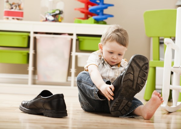 Boy (2-3) putting on dad's shoes. Photo: Mike Kemp
