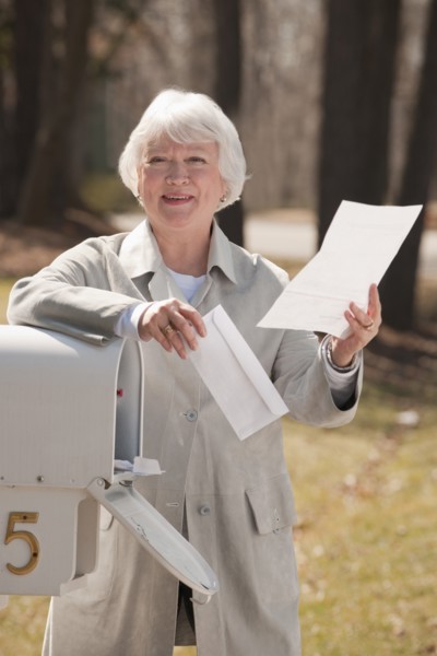 USA, Virginia, Richmond, senior woman reading letters by mailbox. Photo : Mark Edward Atkinson