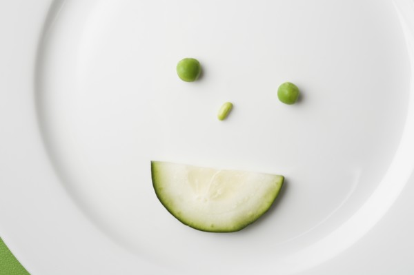 Anthropomorphic face made up from green peas and cucumber slice. Photo : Kristin Lee