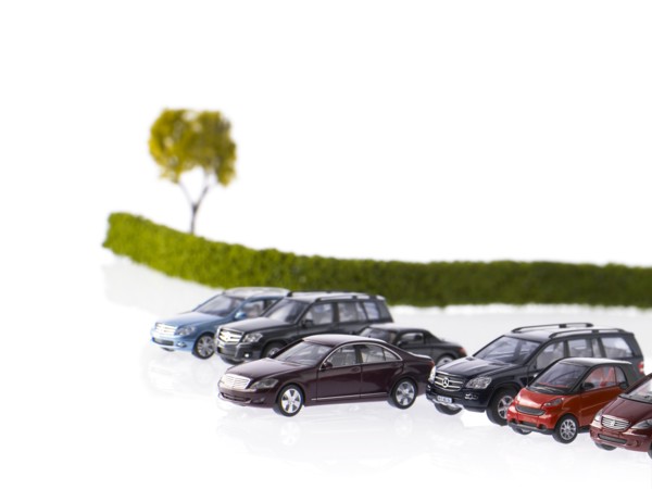 Row of different cars parked near field. Photo: David Arky