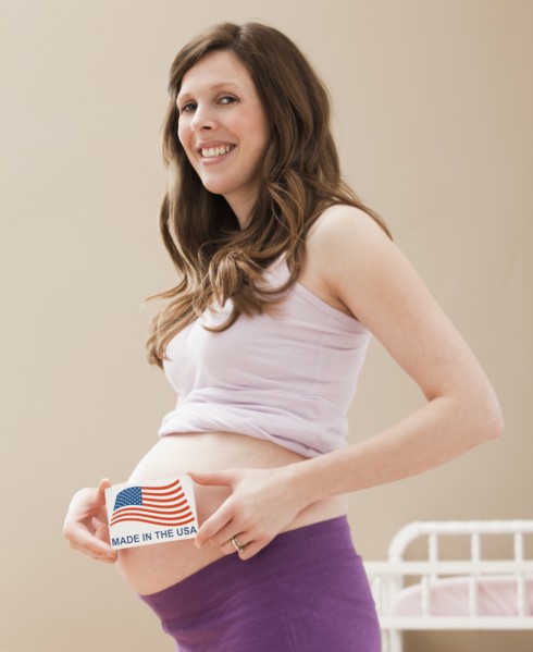 Young pregnant woman holding Made in the USA Sign. Photo: Mike Kemp