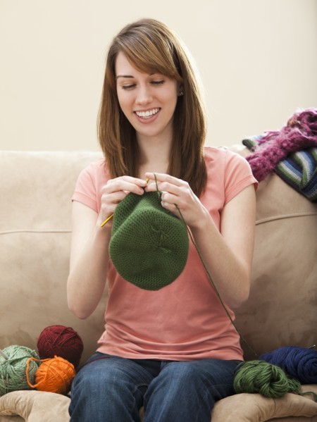 Young woman knitting woolly hat. Photo : Mike Kemp
