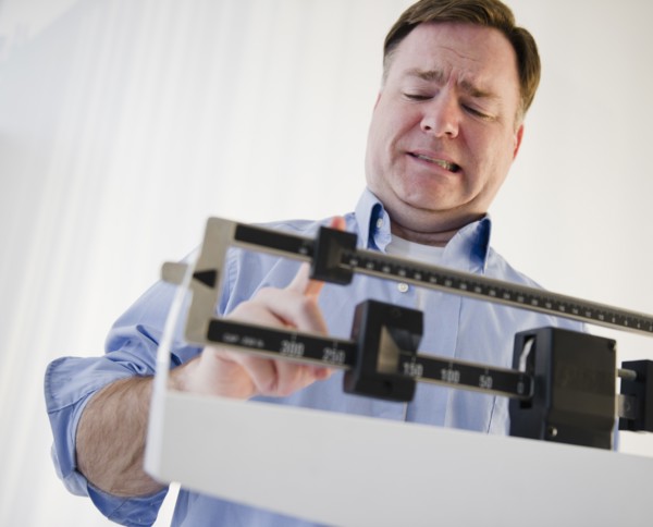 Man on weight scales. Photo : Jamie Grill Photography