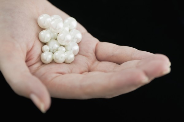 Woman holding pearls.
