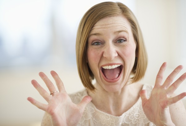 Portrait of excited woman screaming.